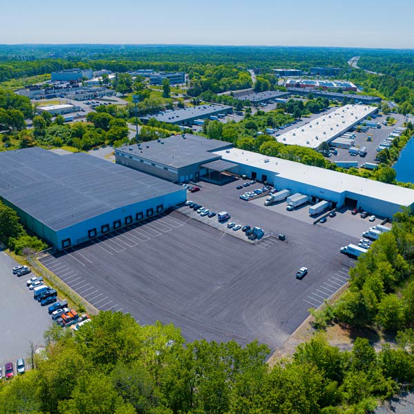 Aerial view of a warehouse with several trucks parked in front